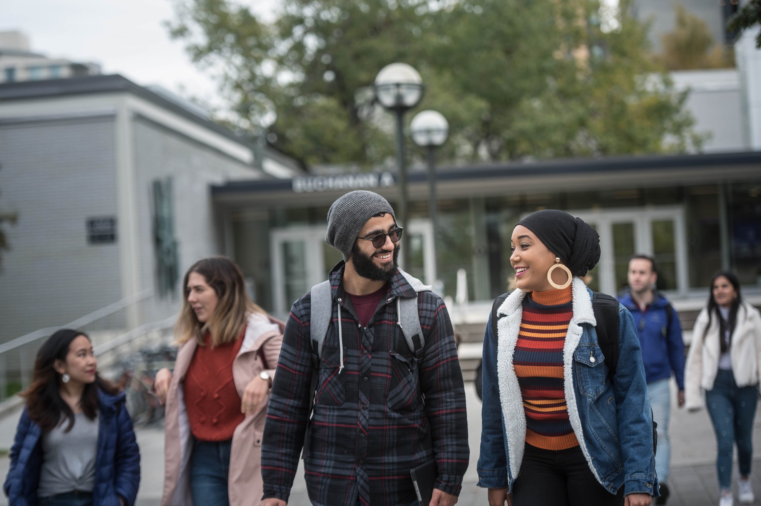 A picture of two Arts students walking and chatting on campus.